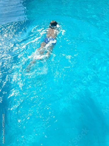 child swimming in blue water