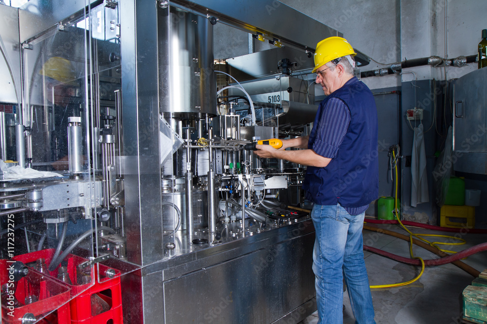 skilled worker while fixing a bottling plant during maintenance work