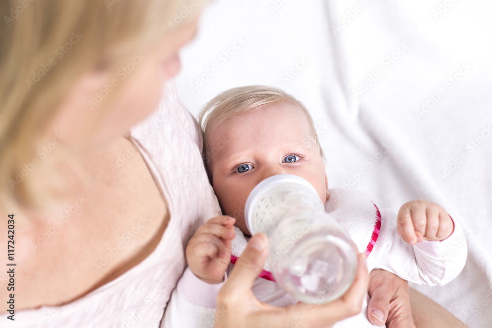 Mutter gibt ihrem Baby das Fläschchen, Closeup Mutter gibt ihrem Baby das Fläschchen, Closeup