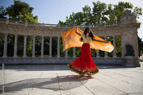 Young beautiful traditional indian woman dancing outdoors