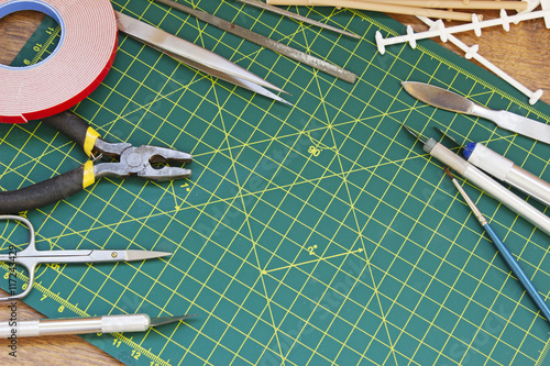 Plastic model kit and tools, hobby workplace background top view.