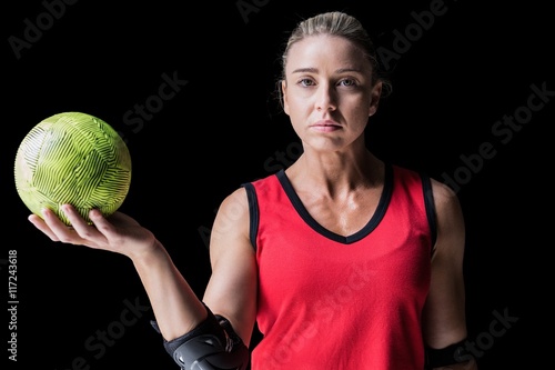 Fototapeta Female athlete with elbow pad holding handball