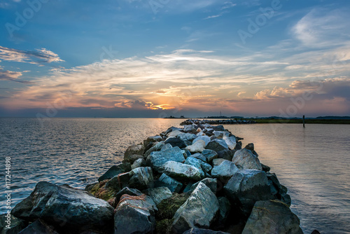 Sunset over a rock jetty on the Chesapeake Bay photo
