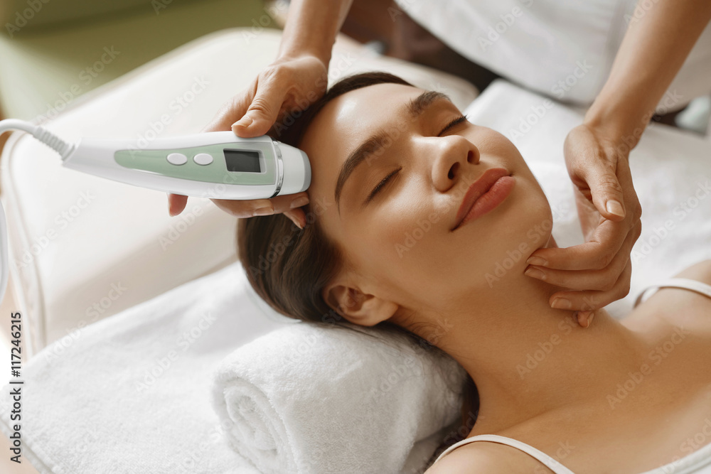 Naklejka premium Skin Care. Women Analyzing Facial Skin With Analyzer. Beauty