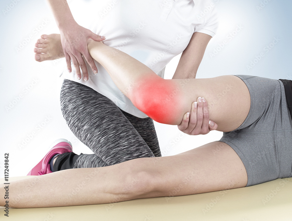 Fototapeta premium Doctor is stretching woman leg.