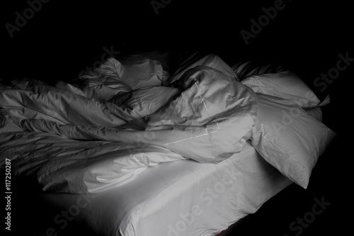 Messy white bed and pillow, in the morning