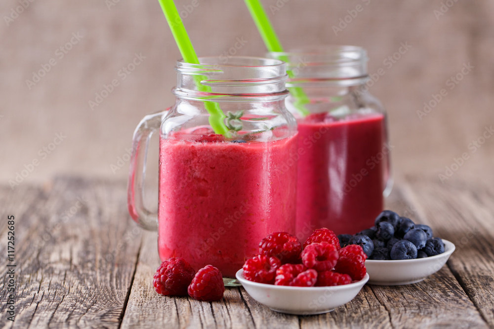 Summer smoothie in glass jar with berries plates. Summer smoothie in glass jar with berries plates.