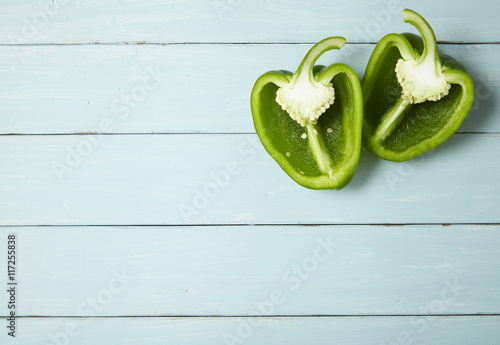 Tela Green sweet bell pepper halves on a rustic painted wooden table top background f