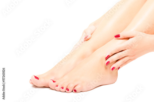 Beautiful female foot and hands with red manicure