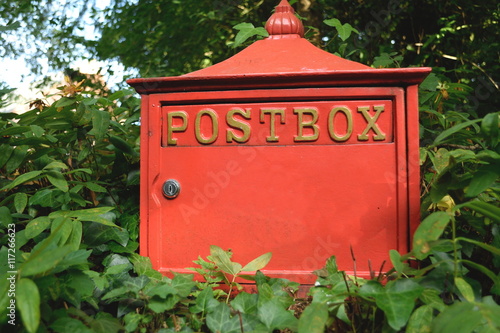Canvas Print Red postbox surrounded by plants