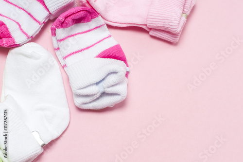 Cotton baby socks for newborn on a colorful pink background. Copy space for text. Top view