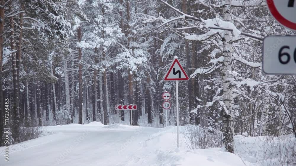 Prohibitory Road Signs on Winter Road/Prohibitory Road signs on winter road. Pine trees covered with snow. Snowing