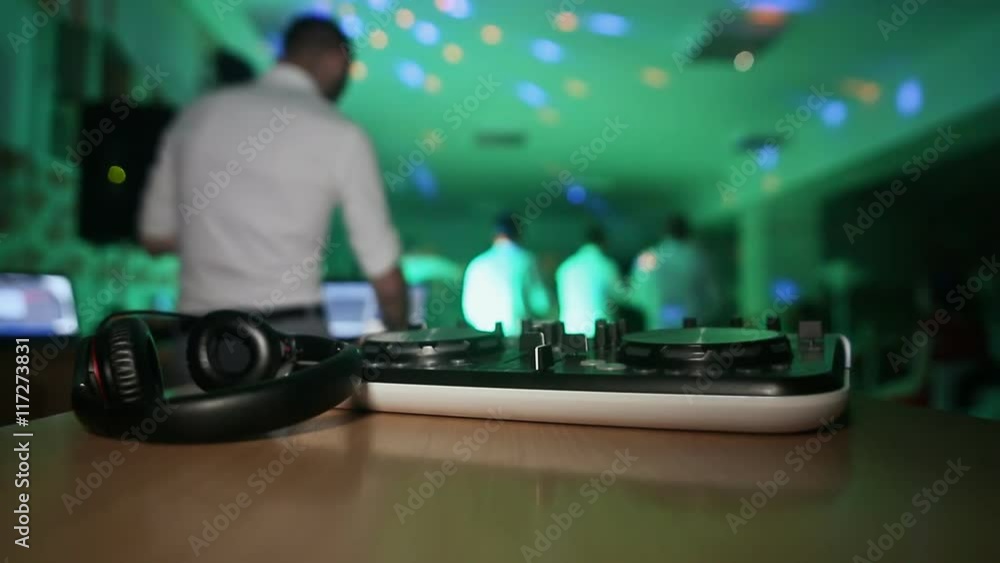 DJ turntable at a party with dancing people DJ turntable at a party with dancing people