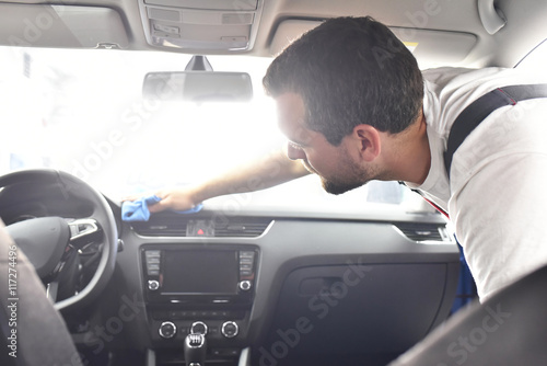 Facharbeiter reinigt Innenraum eines Fahrzeuges mit einem Lappen // inside car cleaning