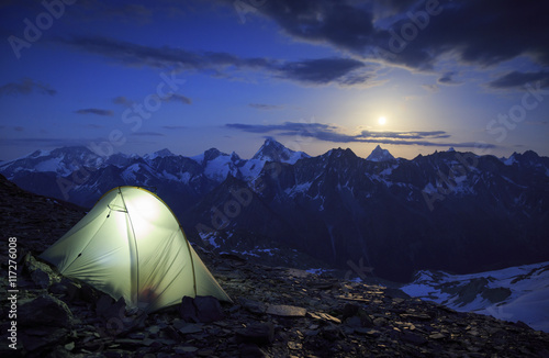 Campsite and the moon rising above the Matterhorn in Wallis, Switzerland. Outdoor and adventure concept.