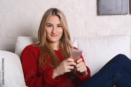 Portrait of young woman sending messages with smartphone.