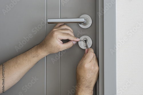 locksmith try to fix a key lock door for open it - can use to display or montage on product photo