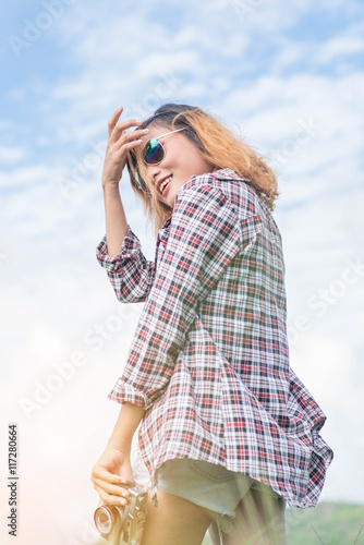 portrait of the beautiful young woman with camera on the sky bac