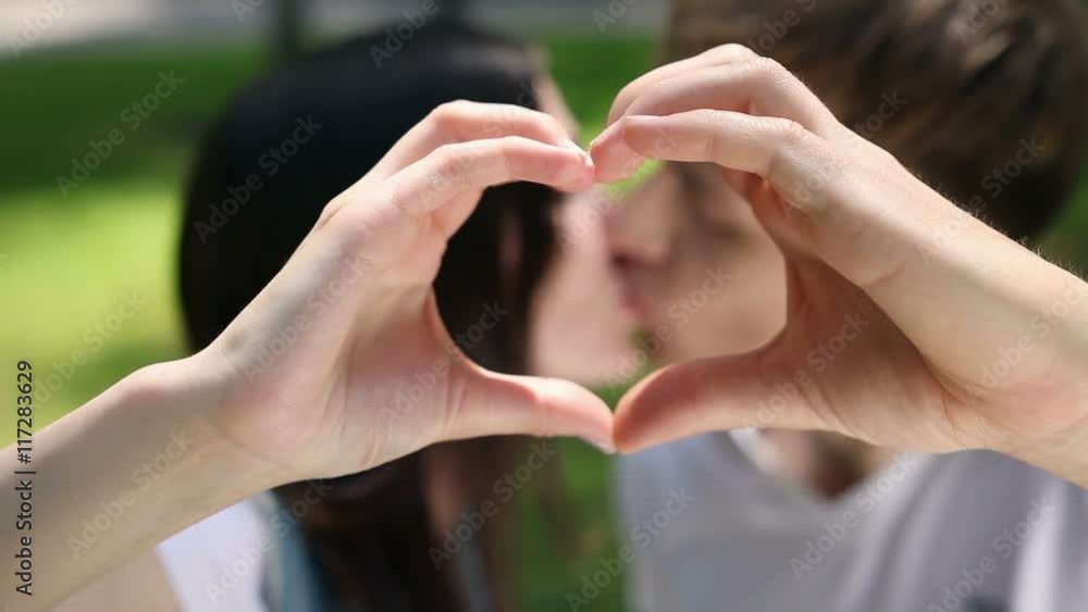 Young couple make a heart out of hand Young couple make a heart out of hand