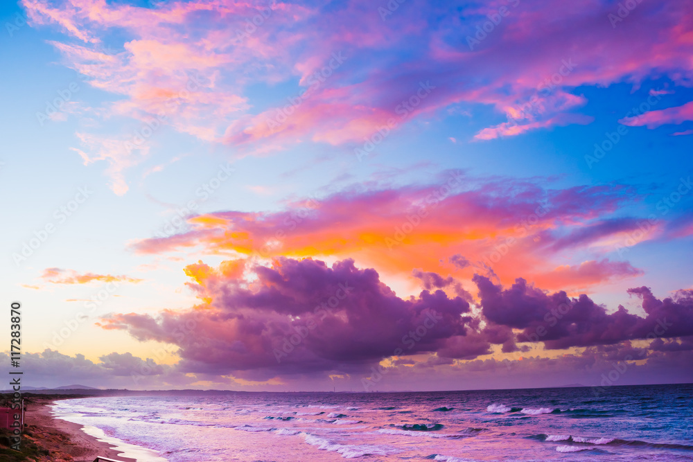 Obraz premium Wonderful sunset over a quiet sea and view of seafront in Sardinia, Italy.