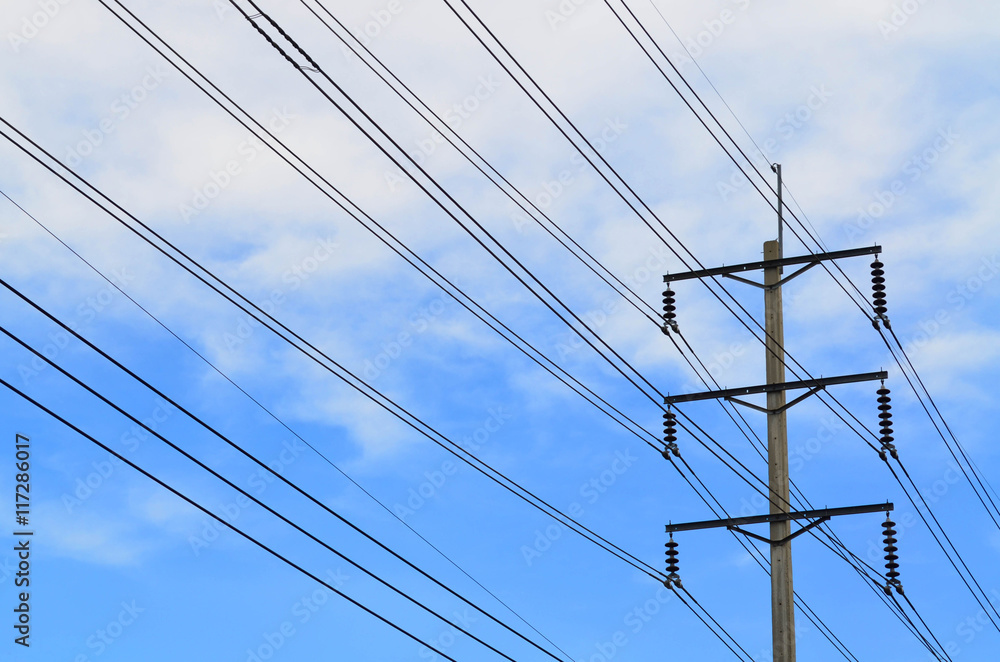 Electrical pole with power lines against hazy blue sky Electrical pole with power lines against hazy blue sky