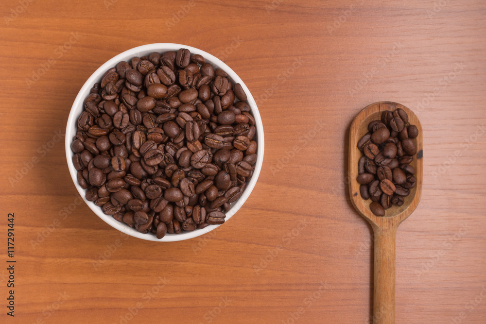 Fototapeta premium Coffee beans into a bowl and spoon. Coffea arabica