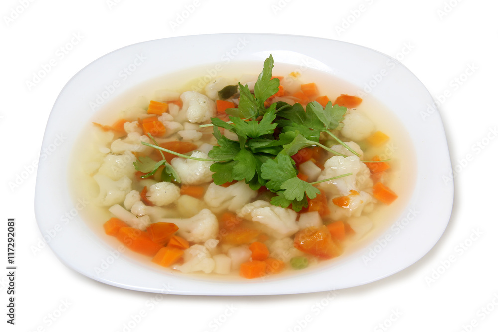 Porcelain plate with vegetable soup on white background