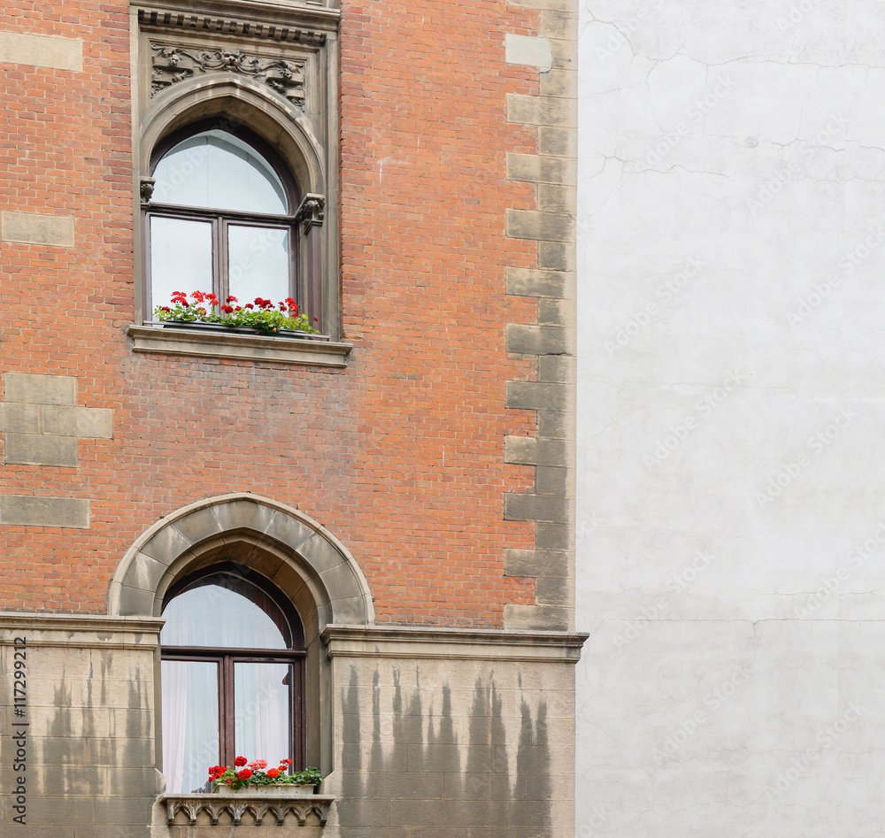 Obraz premium old brick wall with arched windows and a wall of gray plaster