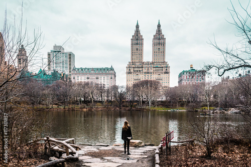 Girl near trees, river and buildings at the Central Park in Manh photo