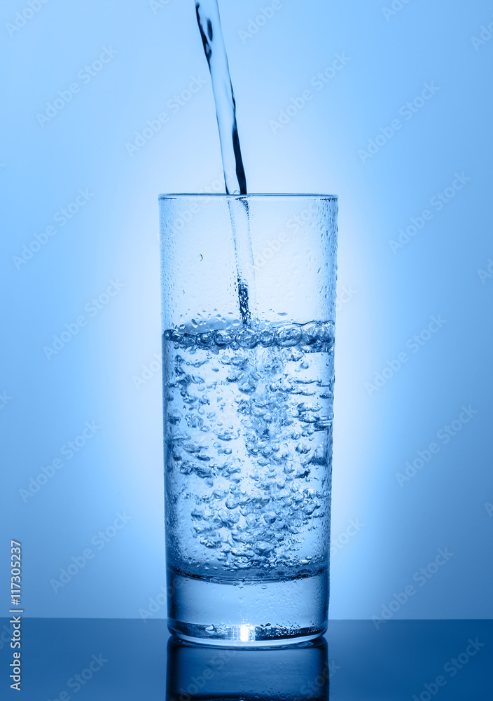 Beautiful glass with water on a blue background Beautiful glass with water on a blue background