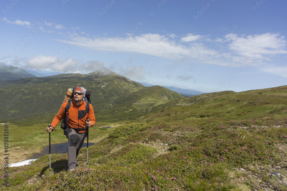 Summer hiking in the mountains with a backpack .