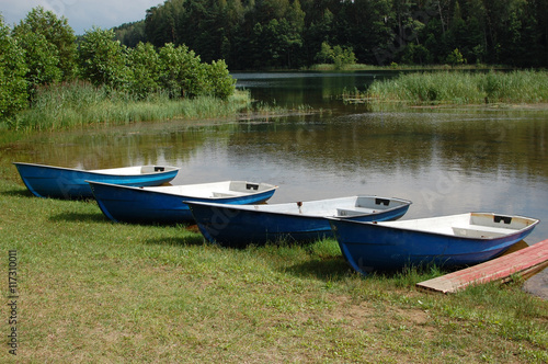 Old Rowboat on a lake in Belarus, summer 2016, four boats on a beach, rent a boats © kodis