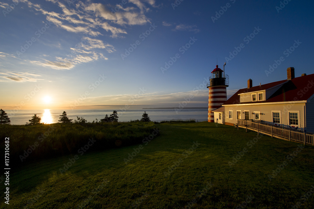 A colorful sunrise behind West Quoddy Head Light in Lubec Maine. A colorful sunrise behind West Quoddy Head Light in Lubec Maine.