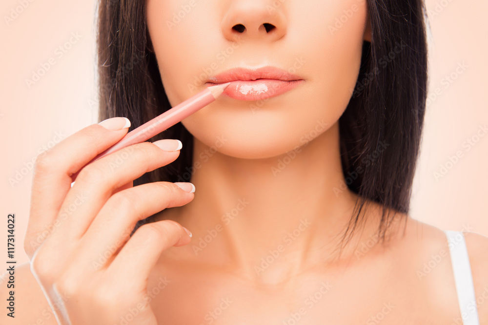 Close up photo of young woman doing maquillage with lip's liner Close up photo of young woman doing maquillage with lip's liner
