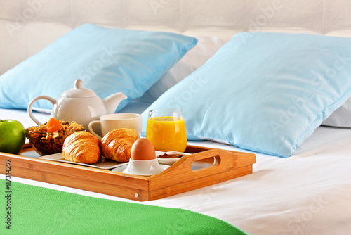 Breakfast on tray in bed in hotel room
