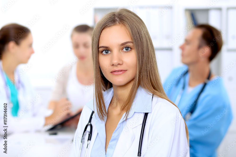 Happy doctor woman with medical staff at the hospital sitting at the table and discussing medical history Happy doctor woman with medical staff at the hospital sitting at the table and discussing medical history