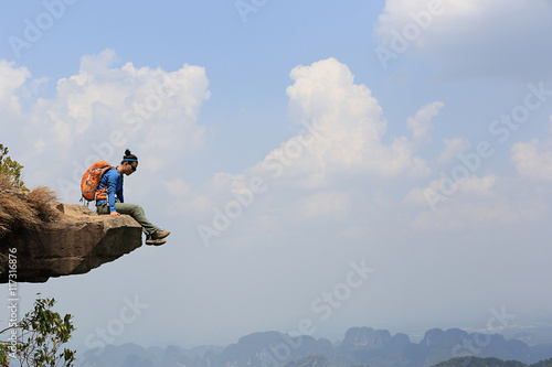 successful woman hiker enjoy the view on mountain top cliff