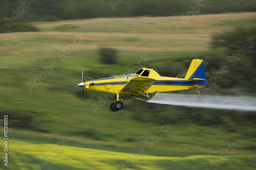 Obraz na plátně Crop duster spraying a crop, taken using a Panning Technique with motion blur