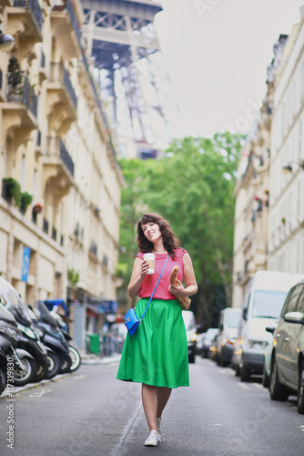 French woman walking with coffee to go and baguette
