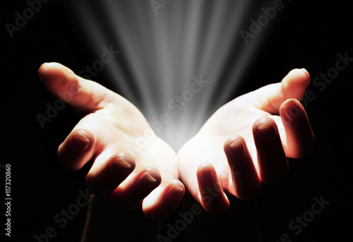 Female hands with light on dark background
