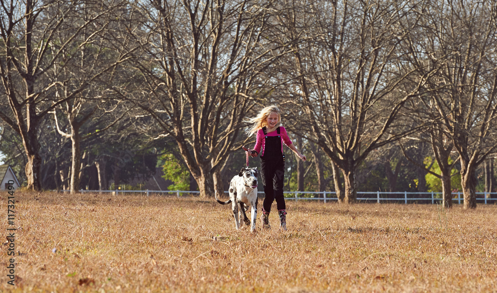 Girl and her dog running playing in open field Girl and her dog running playing in open field