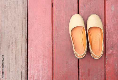 girl shoes over wooden deck floor.
