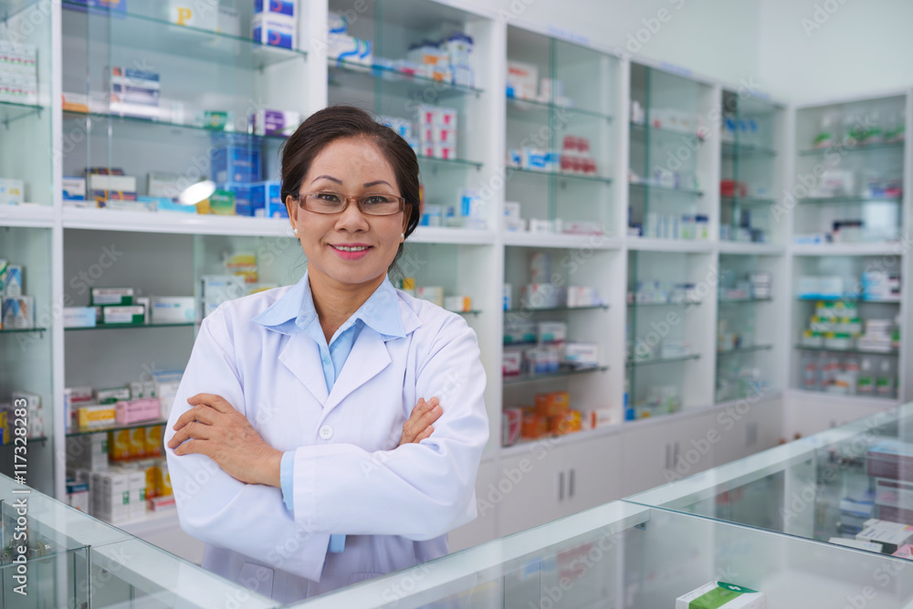 POrtrait of confident Asian pharmacist smiling at camera