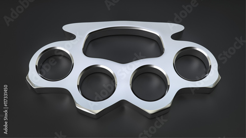 Chrome knuckle duster on a soft black surface under elegant studio lighting.
