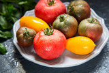 Colorful tomatoes of different sizes and kinds with basil. selec