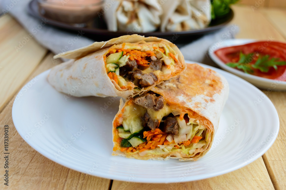 Shawarma - Middle East (Arabic) dish of pita (lavash) stuffed with: grilled meat, sauce, vegetables Shawarma - Middle East (Arabic) dish of pita (lavash) stuffed with: grilled meat, sauce, vegetables