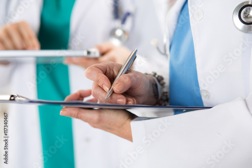 Close up view of medical doctor hands making some notes photo