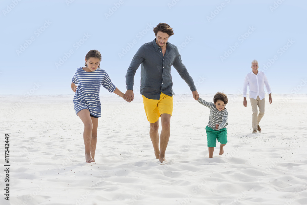 Multi-generation family walking on the beach Multi-generation family walking on the beach