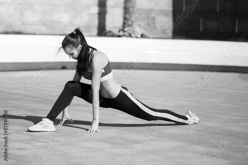 Beautiful fit young woman urban fitness stretching