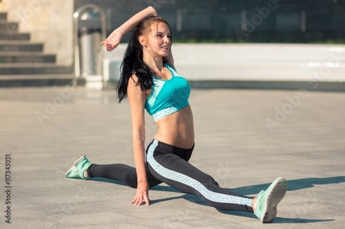 Beautiful fit young woman urban fitness stretching © patramansky